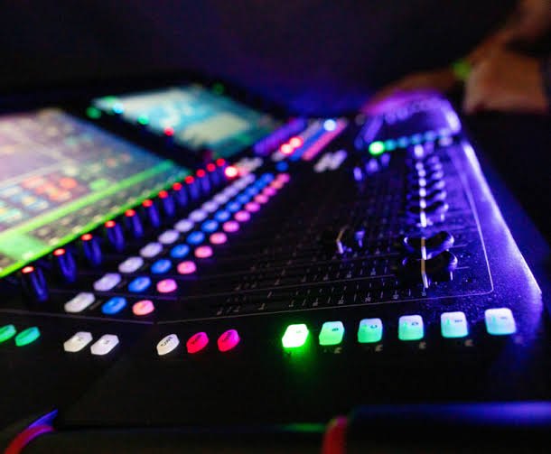 Digital front-of-house mixing console lit up during a show